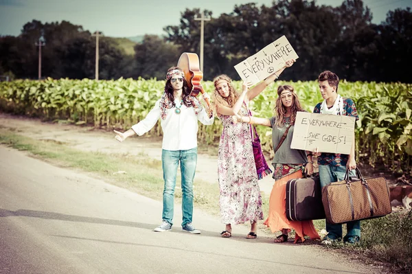 Ομάδα hippie ωτοστόπ σε ένα δρόμο εξοχή — Φωτογραφία Αρχείου