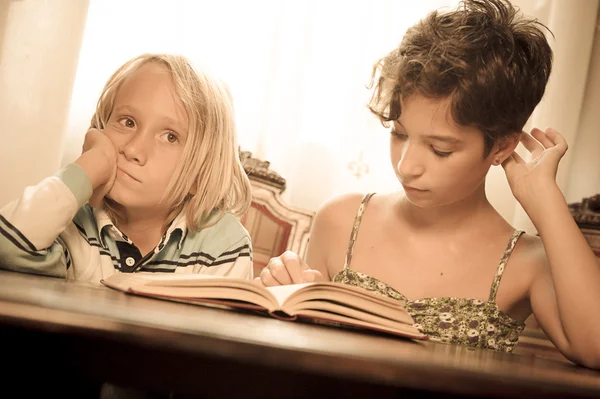 Retratos de crianças jovens lendo um livro — Fotografia de Stock