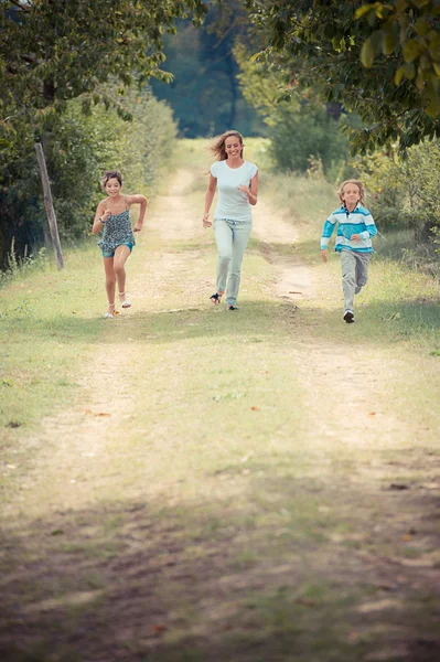 Mooie jonge vrouw met twee kinderen buiten — Stockfoto