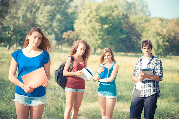 Ritratto felici giovani studenti nel parco — Foto Stock