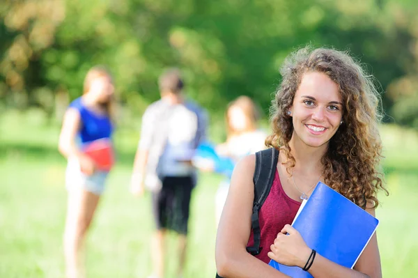 Jonge vrouwelijke student in het park — Stockfoto
