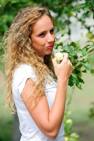 Hermosa joven alegre mujer muerde manzana — Foto de Stock