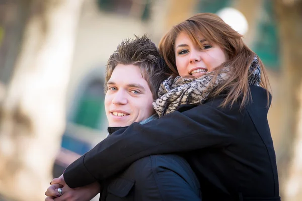 Feliz pareja piggyback abrazos en invierno parque amor sonriendo f — Foto de Stock