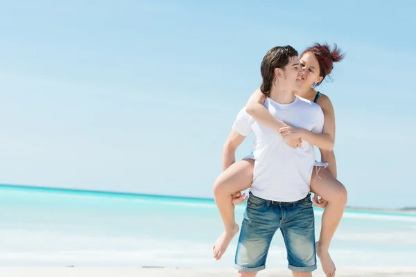 Retrato de um jovem casal feliz se divertindo na praia — Fotografia de Stock