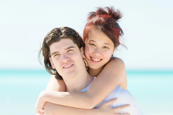 Retrato de um jovem casal feliz se divertindo na praia — Fotografia de Stock