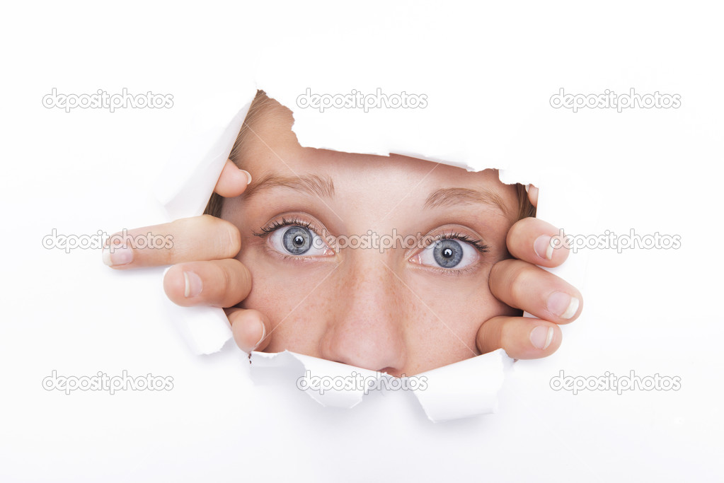 Young woman looks through a hole