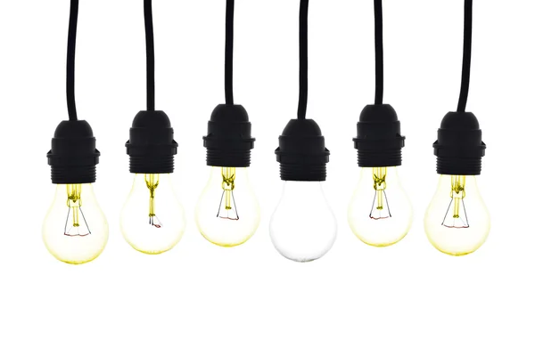 A white light bulb in the middle of yellow bulbs hanging — Stock Photo, Image