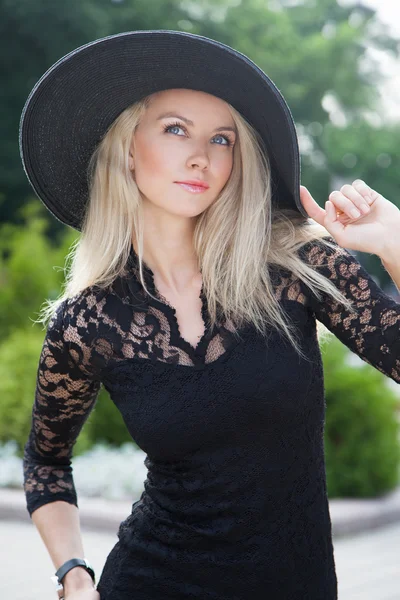 Dívka drží její klobouk s rukou — Stock fotografie