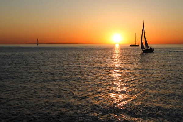 De gouden silhouetten van boten op zee — Stockfoto