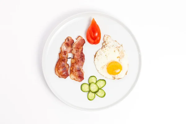 Fried eggs, bacon and vegetables on white background — Stock Photo, Image