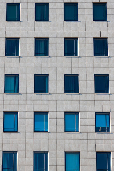 Windows of the multi-storey building of glass and stone