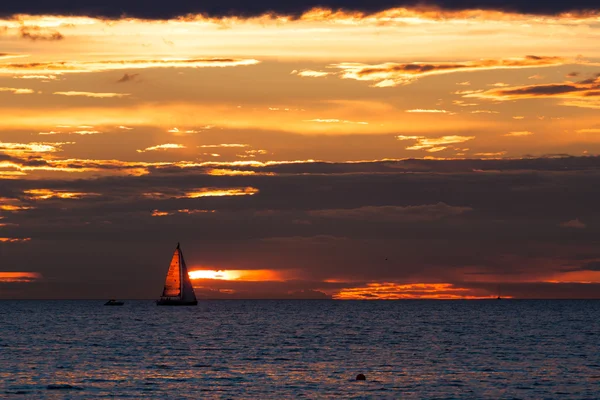 Sailing boat silhouette at sunset in sea — Stock Photo, Image