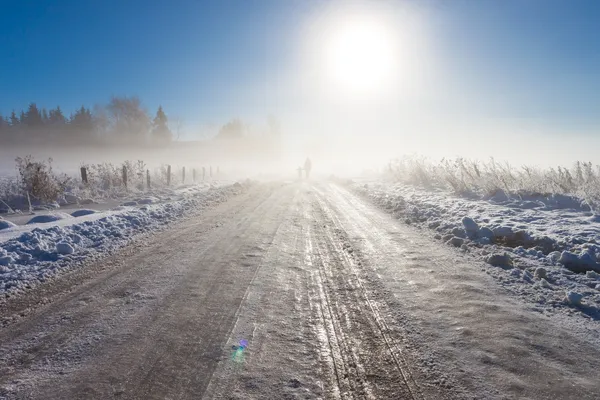 Mother and child on foggy snow road — Stock Photo, Image