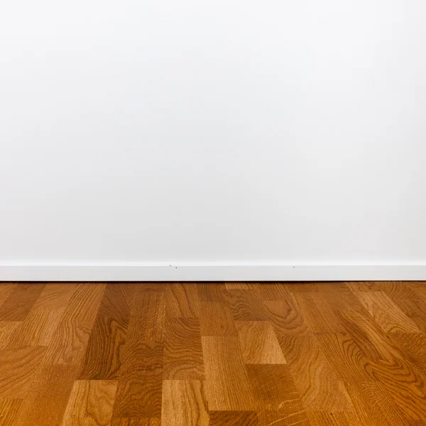 Άδειο λευκό τοίχο και ξύλινο πάτωμα — Φωτογραφία Αρχείου