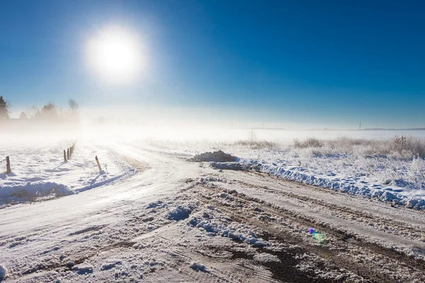 Paisaje de invierno en la niebla con el camino — Foto de Stock
