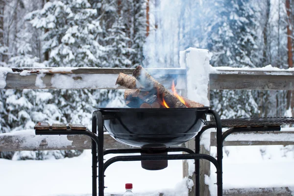 Barbecue en métal avec un bois brillant Photo De Stock