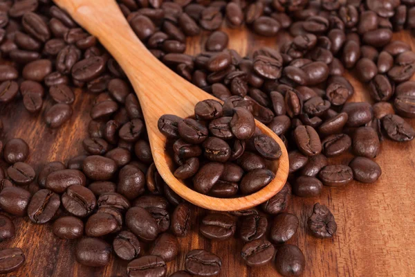 Coffee beans and wood spoon — Stock Photo, Image