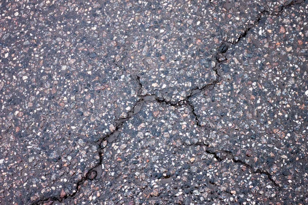 Vieux asphalte usé et fissuré humide — Photo