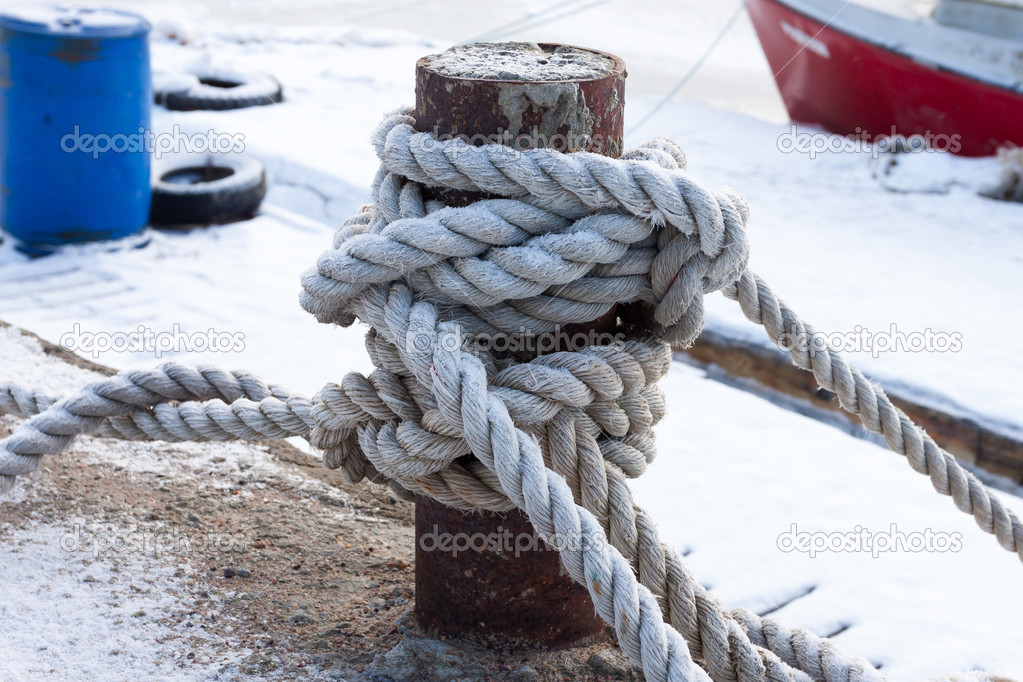 old bollard and frozen ship cable