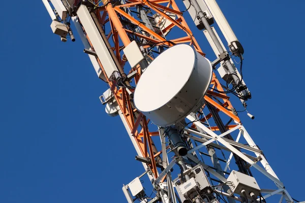 Torre de comunicaciones con antenas en el cielo azul — Foto de Stock