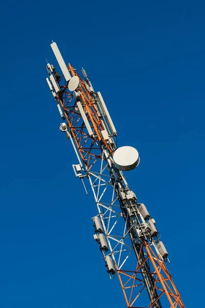 Torre de comunicaciones con antenas en el cielo azul — Foto de Stock