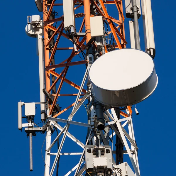 Communications tower with antennas on blue sky — Stock Photo, Image