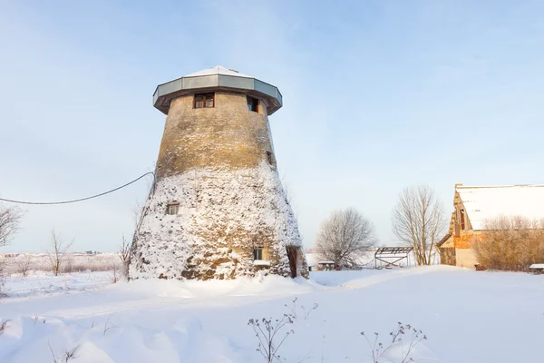 Stympad väderkvarn, ett hus och snö — Stockfoto