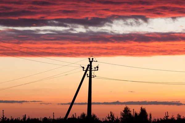Línea eléctrica contra el cielo colorido al atardecer — Foto de Stock