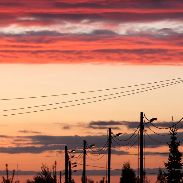 Linha elétrica contra o céu colorido ao pôr do sol — Fotografia de Stock