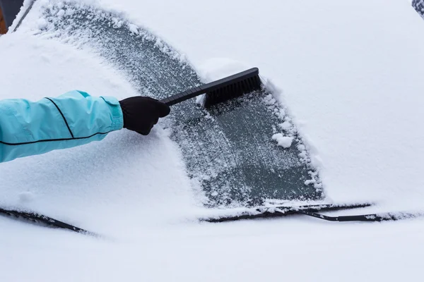 Mulher limpando neve do carro — Fotografia de Stock