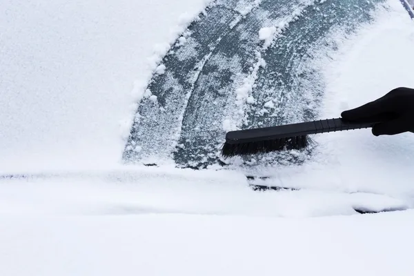 Mujer limpiando nieve del coche — Foto de Stock