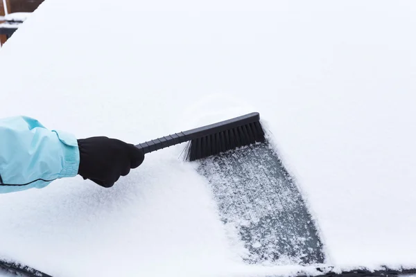 Женщина убирает снег из машины — стоковое фото
