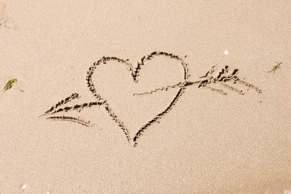 Srdce s šipkou na písku — Stock fotografie