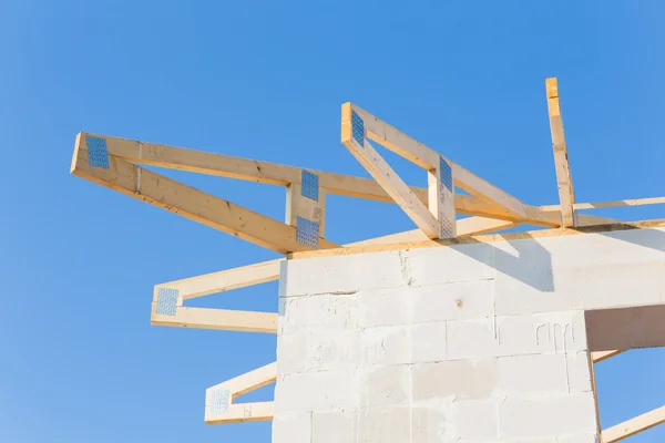Nova casa de construção residencial enquadrando contra um céu azul — Fotografia de Stock