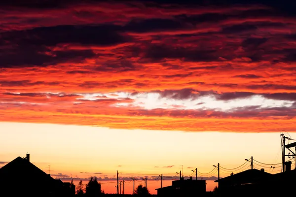 Coucher de soleil illumine les nuages au-dessus d'une rue urbaine — Photo