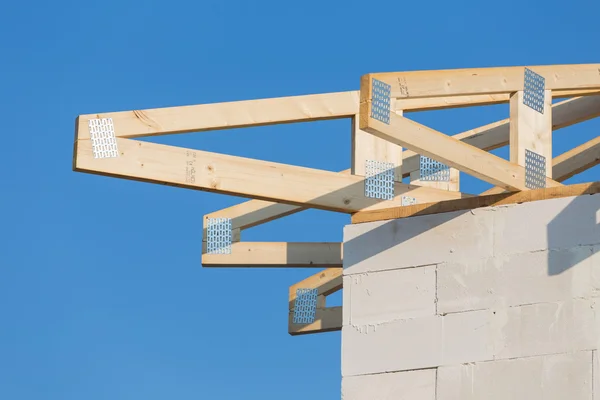 Nova casa de construção residencial enquadrando contra um céu azul — Fotografia de Stock