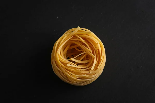 Fettuccine Pasta Nest Zwarte Steen Achtergrond — Stockfoto