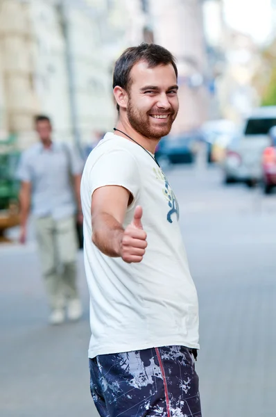Portrét veselý mladík. ukazuje palec nahoru. Cool. — Stock fotografie