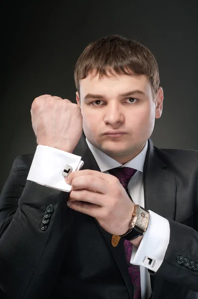 Young man buttoning cuff links and watches in the frame. — Stock Photo, Image