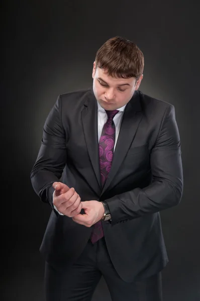 A young man in a suit corrects cufflinks — Stock Photo, Image