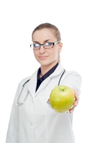 Un médecin avec un stéthoscope et une pomme. Sur fond blanc . — Photo