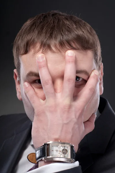 Young man screaming face in his hands.