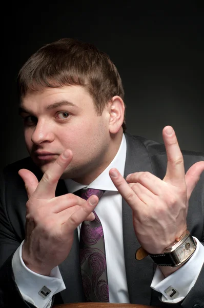 Man in a jacket to show a gesture of the fingers, a goat. Steep — Stock Photo, Image