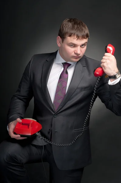 Mężczyzna rozmawia czerwony telefon. — Zdjęcie stockowe