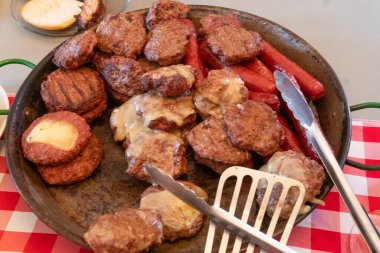 Barbekü köftesi ve tavada sosisli sandviç.
