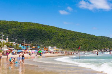 Bombas, Santa Catarina, Brezilya - 19 Aralık 2021: insanlar kıyı boyunca yürür. Güzel tropik Bombas plajı, Santa Catarina.