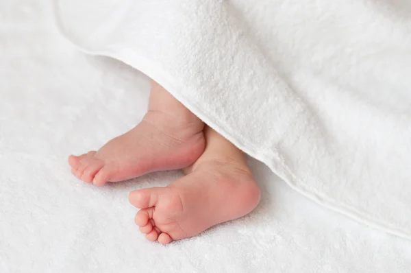 Babyfüße in einem weißen Handtuch — Stockfoto
