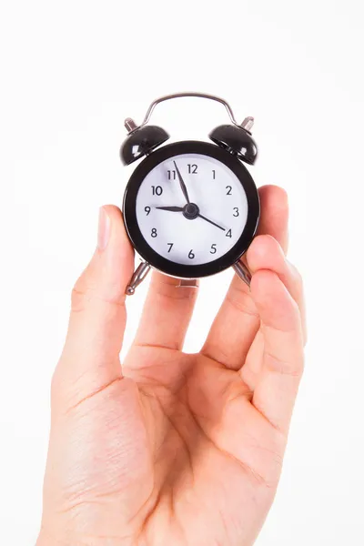 Hand bedrijf alarm clock Rechtenvrije Stockafbeeldingen