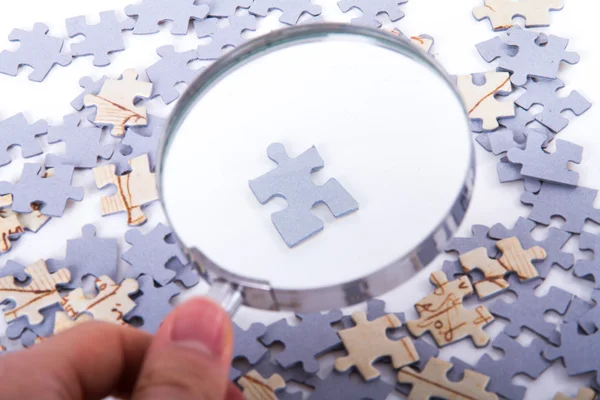 Lupe und einzelnes Puzzleteil — Stockfoto