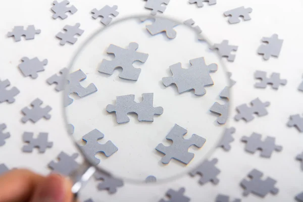 Magnifying Glass on Puzzle Pieces — Stock Photo, Image